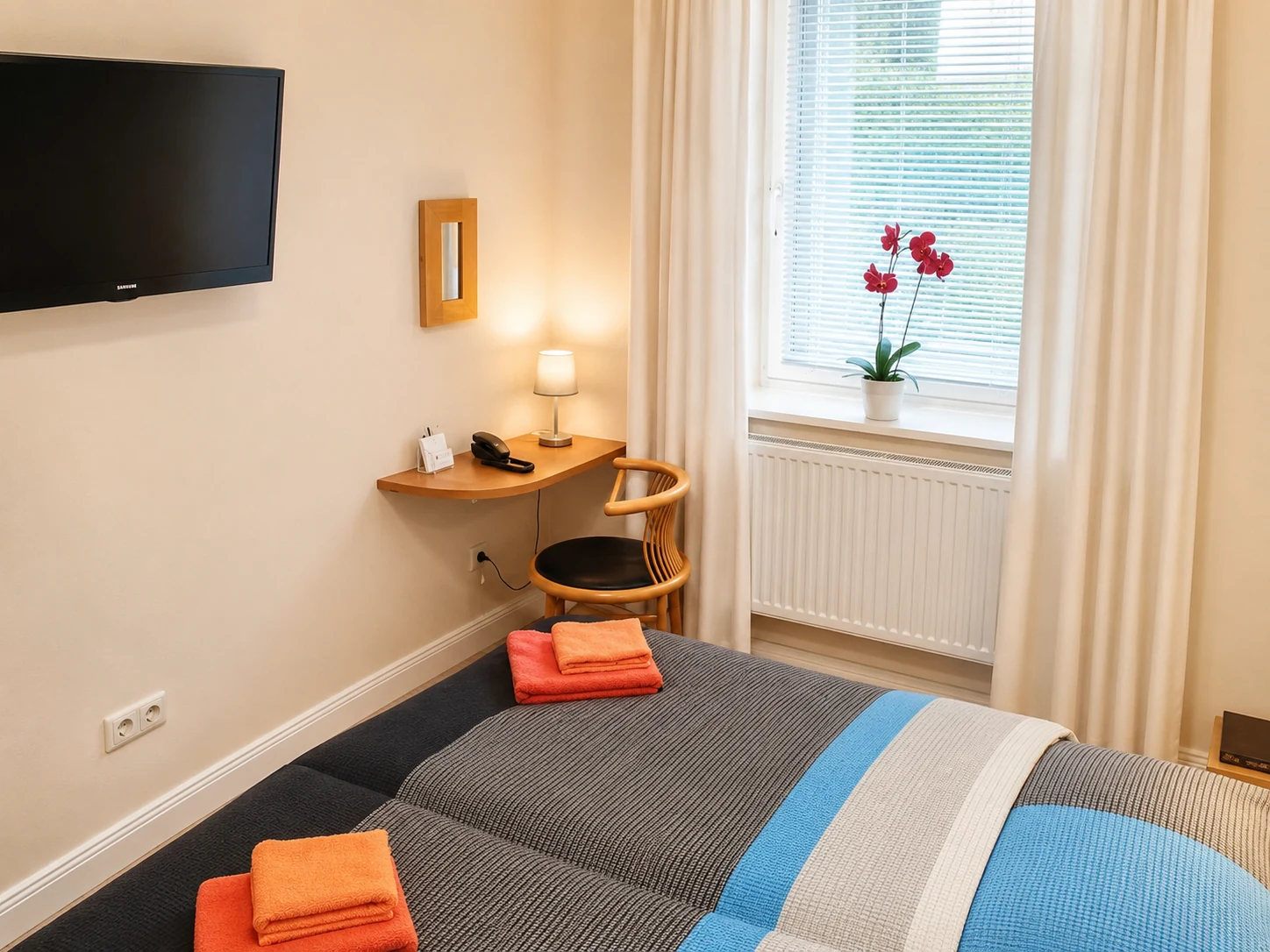 Einzelzimmer mit Bett, Schreibtisch und Fenster